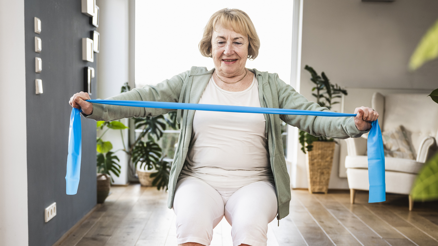 Woman exercising with resistance band in domestic setting