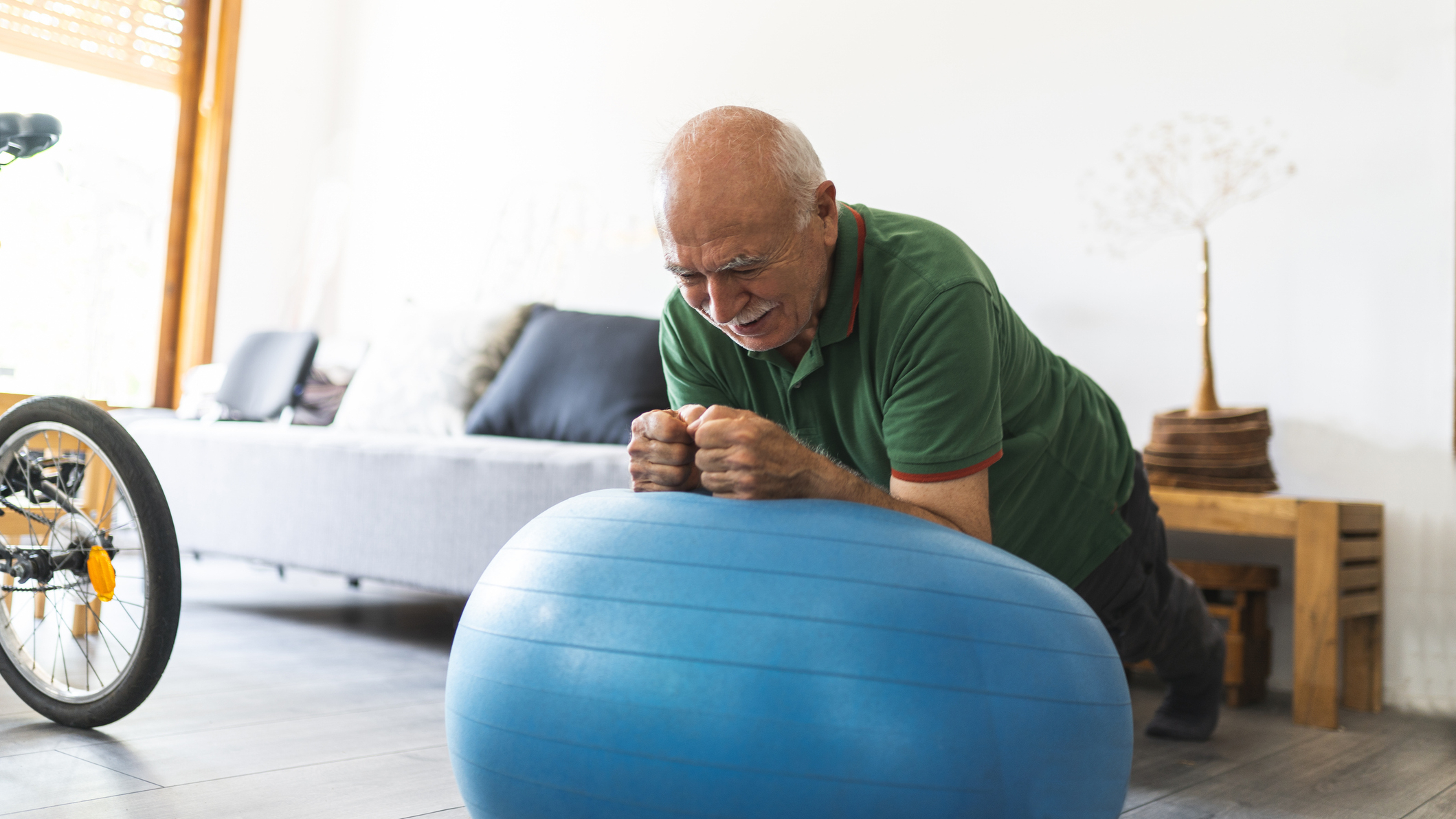 Man exercising at home using a stability ball