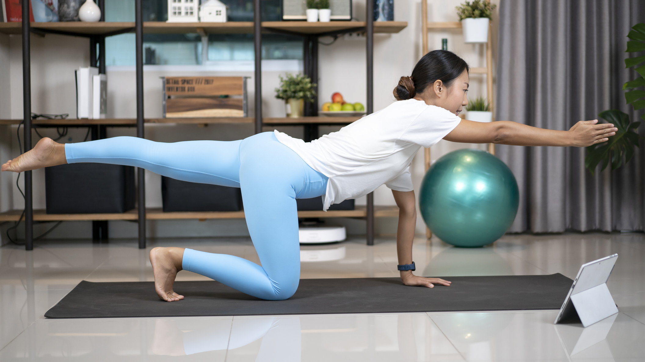 Woman performing the bird dog exercise in a domestic setting. 