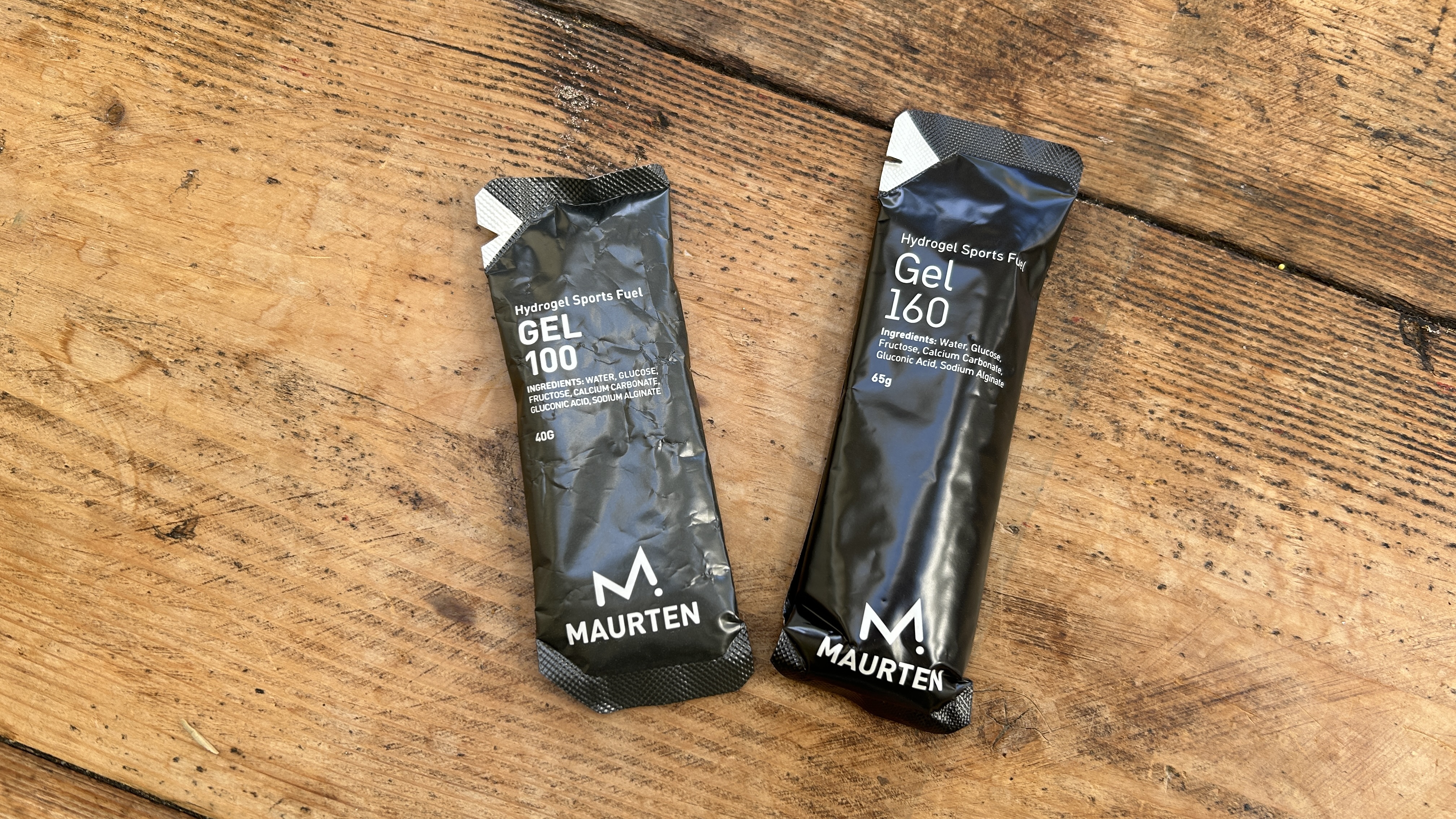 Maurten 100 and 160 energy gels on a wooden table