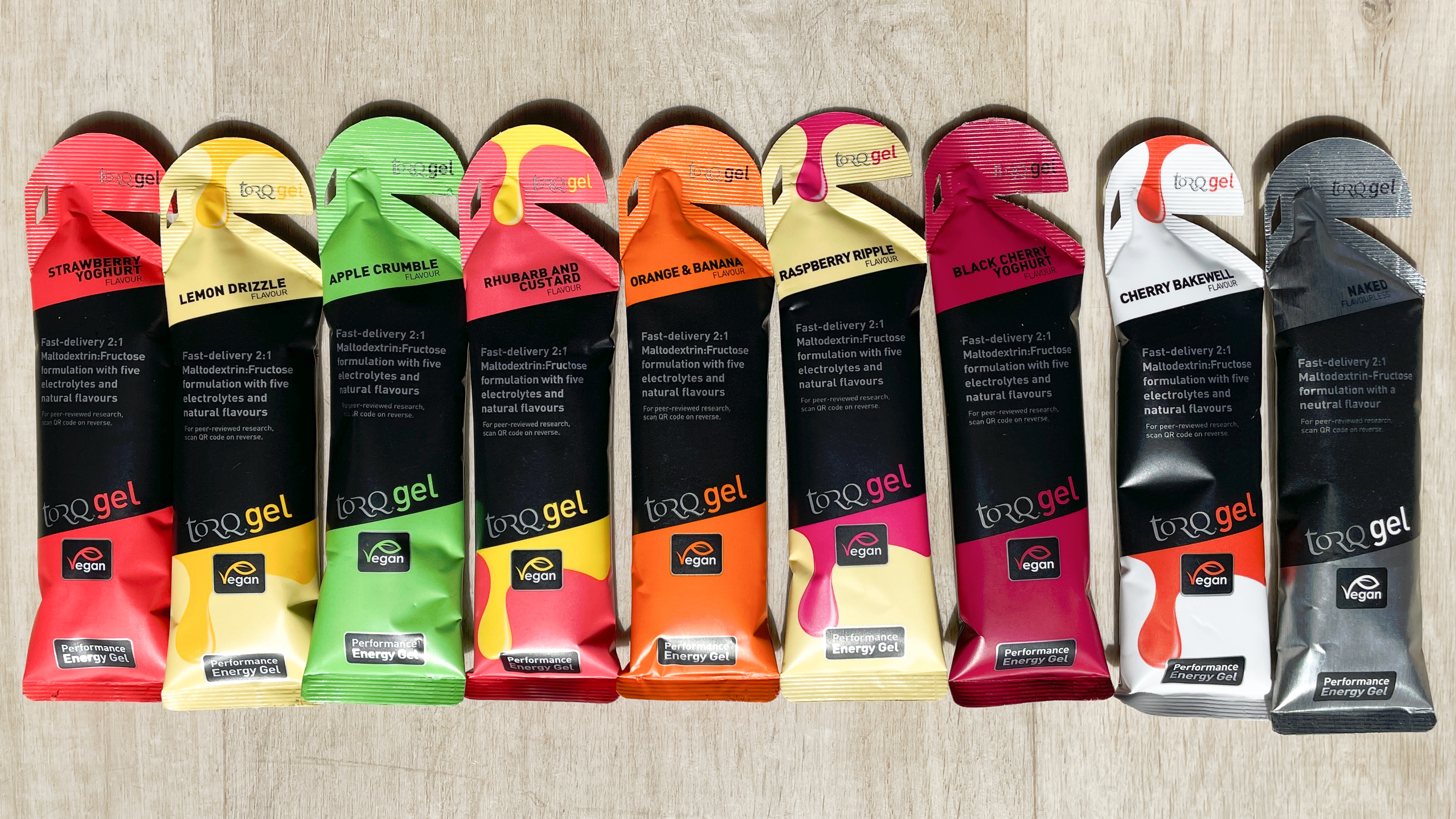 A selection of Torq energy gels lined up on a wooden floor