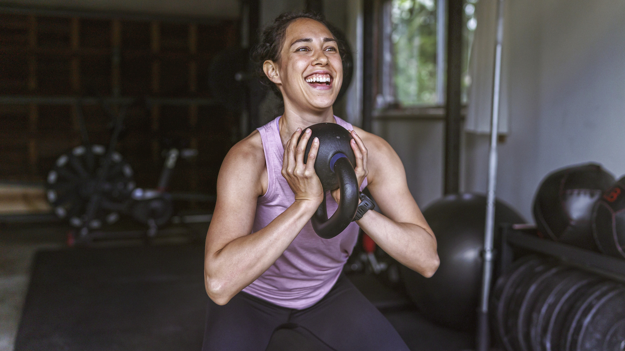 Smiling woman exercising with kettlebell