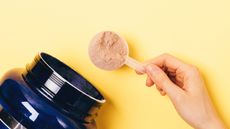 Person measuring a serving of protein powder