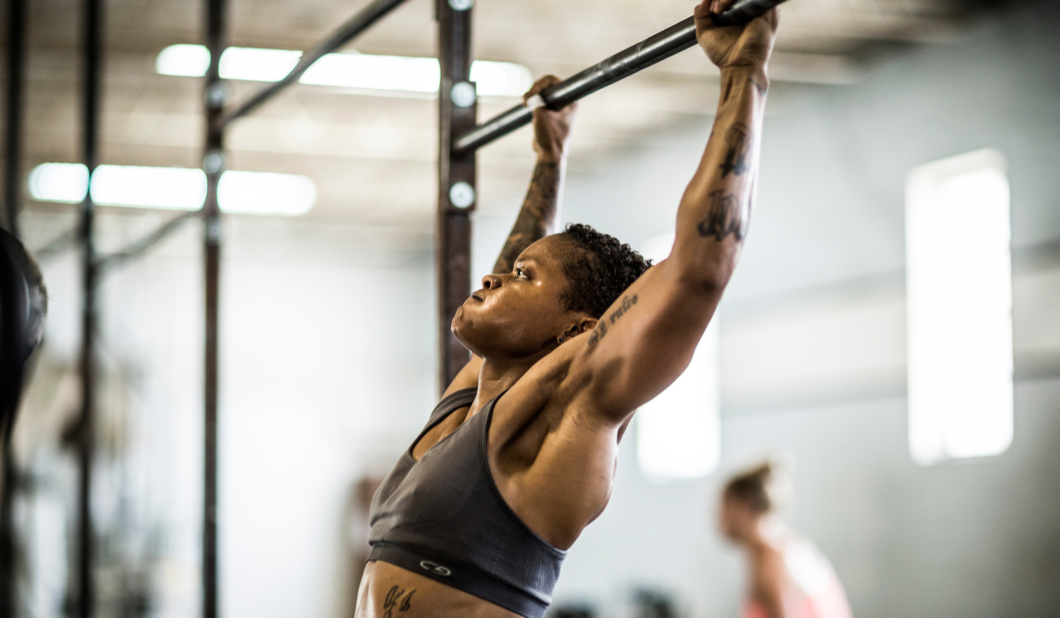 Woman doing pull-ups in a gym 