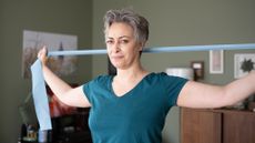 Woman stretching at home using strap