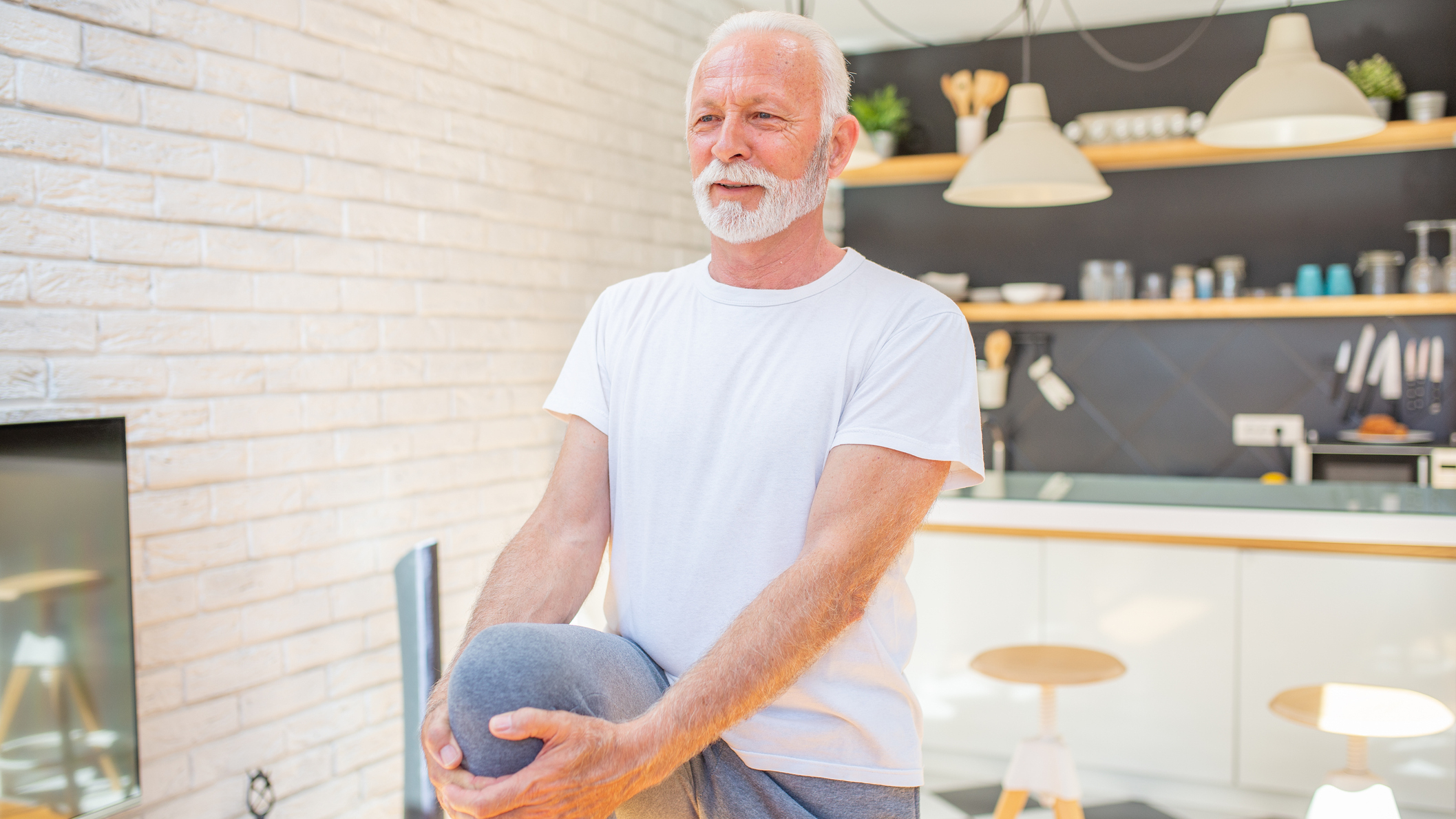 Man balancing on one leg in domestic setting