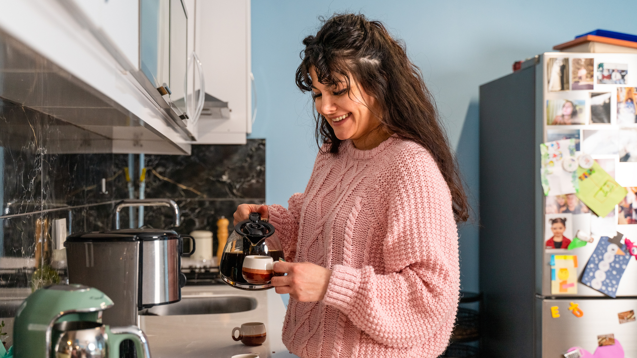Woman pouring coffee in a kitchen
